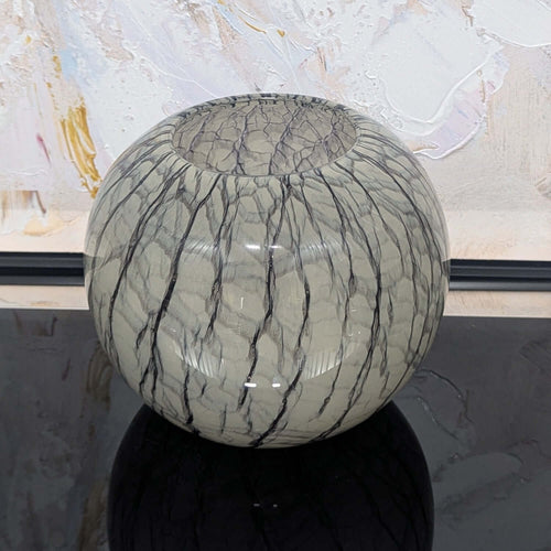 Glass vase with crackle pattern on a reflective surface