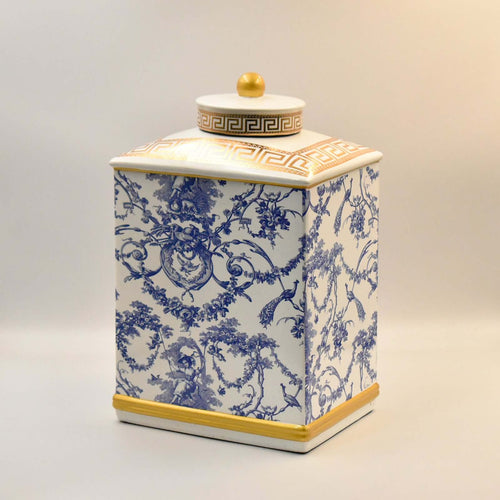 Ceramic jar with blue floral pattern and gold accents on a beige background