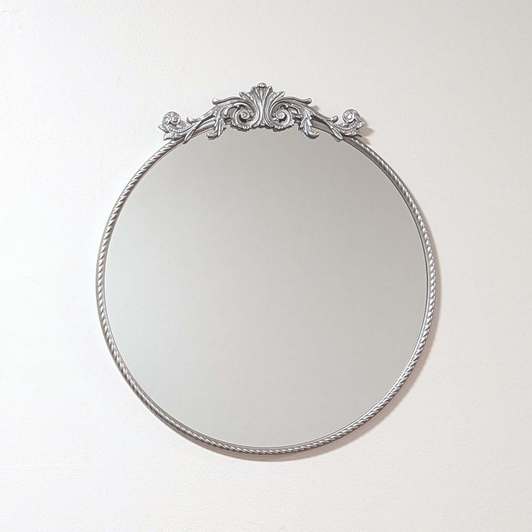 Elevate your space with the Baroque Silver Round Mirror. This 60x60 cm decorative wall mirror features a stunningly ornate silver frame, showcasing classic Baroque style influence. It adds vintage charm and sophistication, perfect as a silver accent mirro
