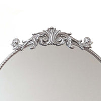 Elevate your space with the Baroque Silver Round Mirror. This 60x60 cm decorative wall mirror features a stunningly ornate silver frame, showcasing classic Baroque style influence. It adds vintage charm and sophistication, perfect as a silver accent mirro