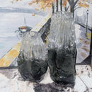 Two textured glass vases on a marble surface with a painting in the background