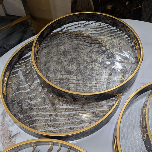 Round glass serving trays with zebra design, champagne gold and brown hues with wood handles, perfect for home ambiance enhancement.
