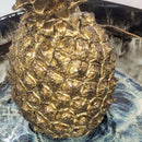 Bronze pineapple sculpture on a marble surface