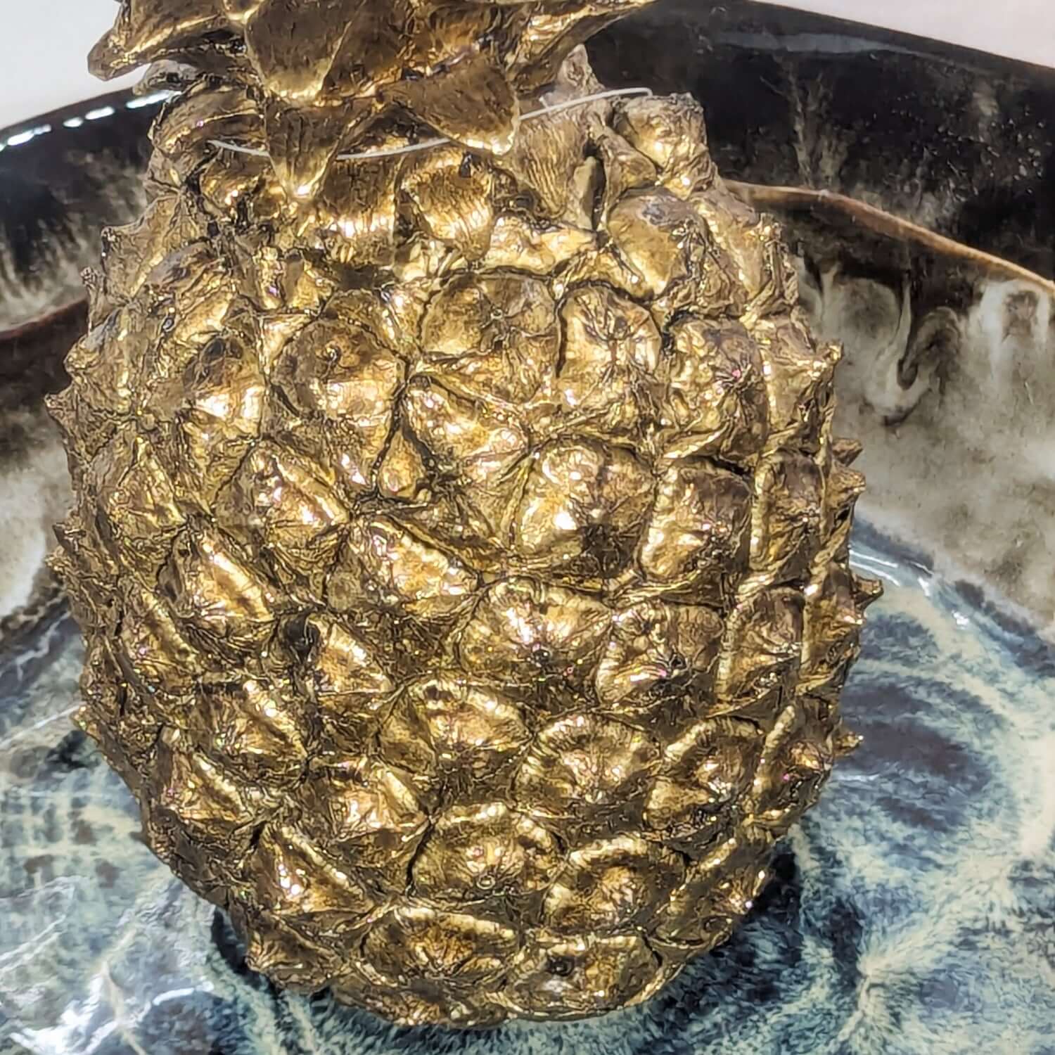 Bronze pineapple sculpture on a marble surface