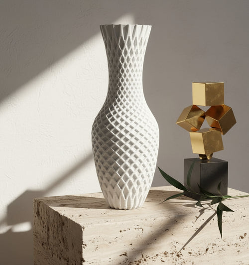 White textured vase on a round marble table with decorative candle holders in the background.