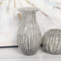 gray marble vases on a light surface with a textured white and gold background