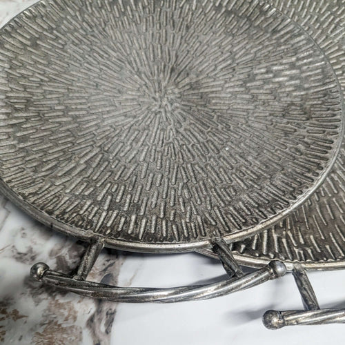 Textured Silver Metal Round Serving Trays - Set of 2 with embossed surface and elegant handles, perfect for tabletop decor.