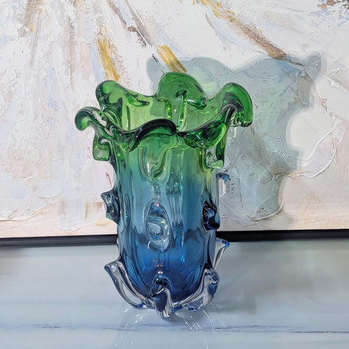 Multicolored glass vase with wavy design on a textured surface