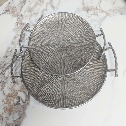 Textured Silver Metal Round Serving Trays - Set of 2 with embossed hammered surface and side handles on a marble background